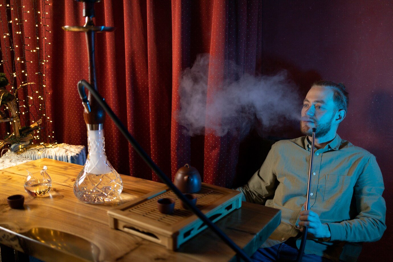 man-relaxing-by-vaping-from-hookah-bar_23-2149191851